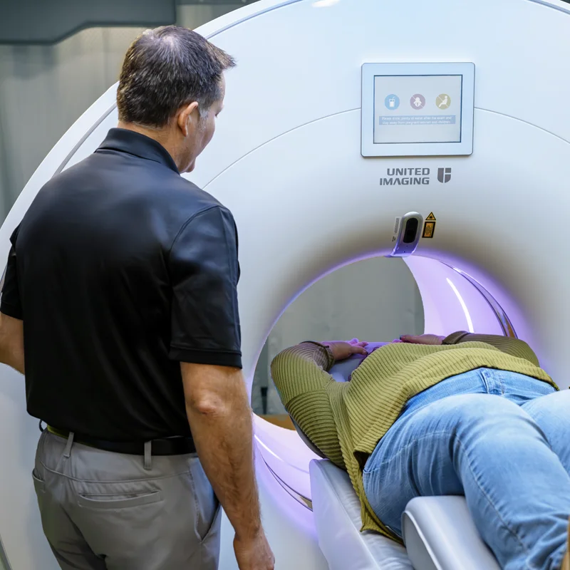 Shared Medical Services technologist guiding a patient into the United Imaging uMI 550 digital PET/CT scanner, delivering high-precision imaging for cardiac and oncology diagnostics with a focus on patient comfort and scan efficiency.