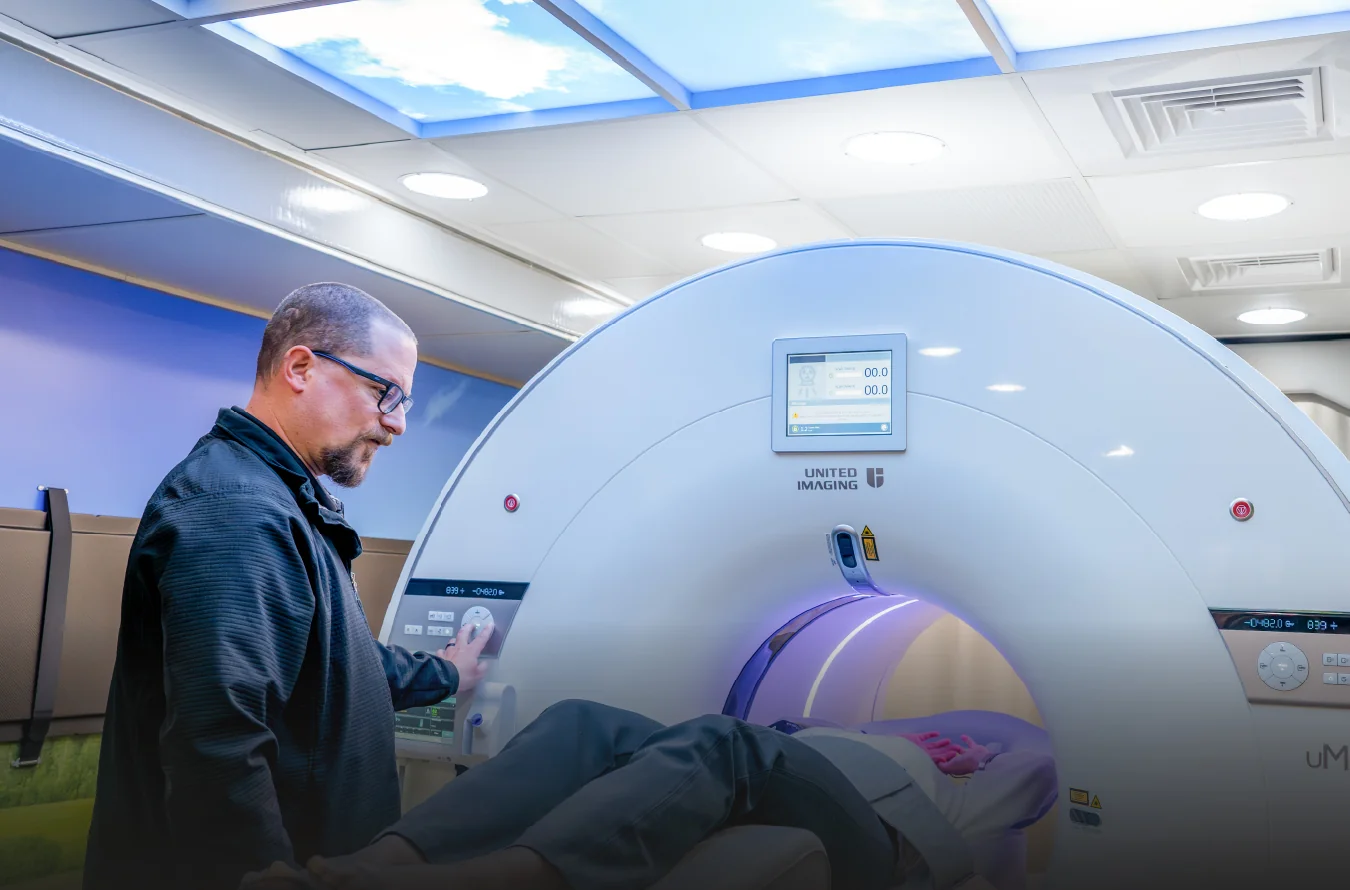 SMS technologist assisting a mobile PET/CT patient An SMS technologist at the controls while a patient lies on the table of a mobile PET/CT scanner.